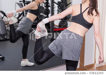 Woman checking bodyline in gym 53812243