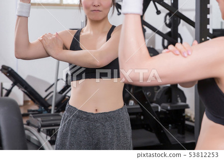 Woman checking bodyline in gym 53812253