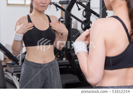 Woman checking bodyline in gym 53812254