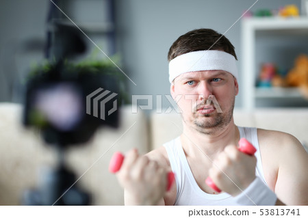 Serious Vlogger Doing Exercise with Dumbbells Serious Vlogger Doing Exercise with Dumbbells 53813741