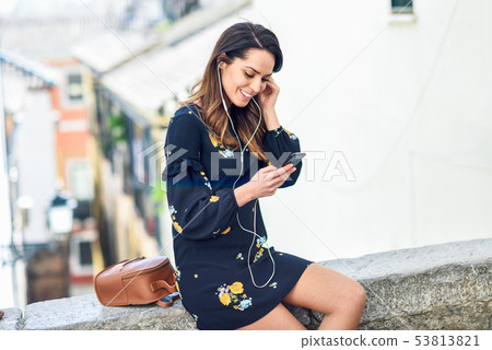 Woman listening to the music with earphones and Woman listening to the music with earphones and 53813821