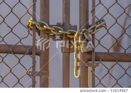 Chain link fence closed with padlock and chain 53814987