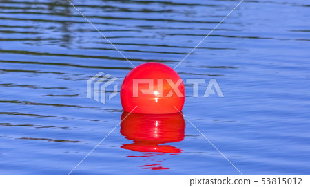 Bright red ball floating on the calm Oquirrh Lake Bright red ball floating on the calm Oquirrh Lake 53815012