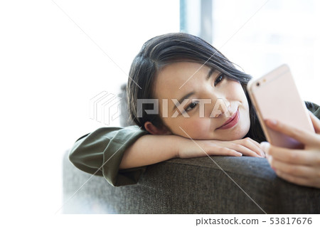 Woman young woman sofa smartphone smart phone lifestyle 53817676