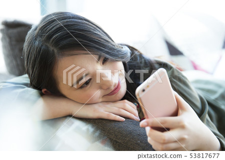 Woman young woman sofa smartphone smart phone lifestyle 53817677