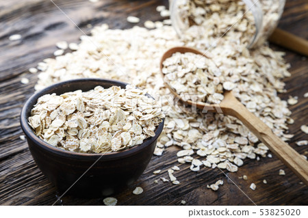 Spoon and bowl with raw oatmeal on the table. Top Spoon and bowl with raw oatmeal on the table. Top 53825020