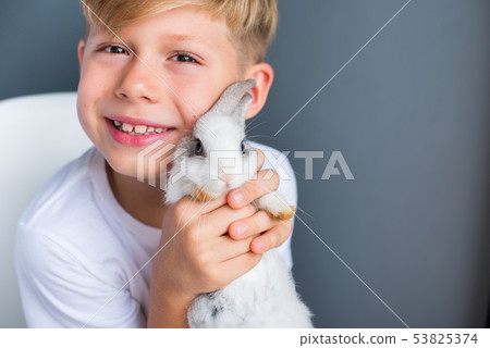 Little boy white Tshirt and tame dwarfish rabbit 53825374