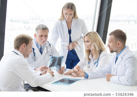 Group of doctors discuss x-ray Group of doctors discuss x-ray 53826396