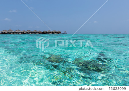 beach with water bungalows at maldivian island 53828099