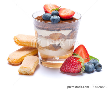 Classic tiramisu dessert with blueberries, strawberries in a glass and savoiardi cookies isolated on 53828839