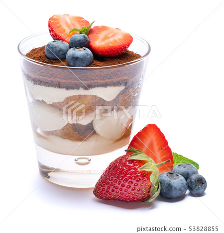 Classic tiramisu dessert with blueberries and strawberries in a glass isolated on a white background 53828855