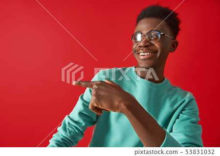Happy Afro American guy is posing on red background 53831032