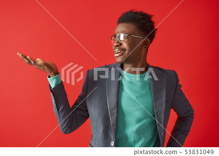 Smiling Afro American man is posing on red background Smiling Afro American man is posing on red background 53831049