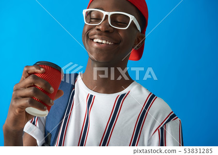 Smiling Afro American student with backpack on blue background Smiling Afro American student with backpack on blue background 53831285
