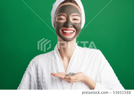Cheerful girl with towel on her head holding cosmetic clay 53831588