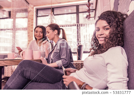 Curly dark-haired woman feeling relaxed while spending weekend with friends Curly dark-haired woman feeling relaxed while spending weekend with friends 53831777