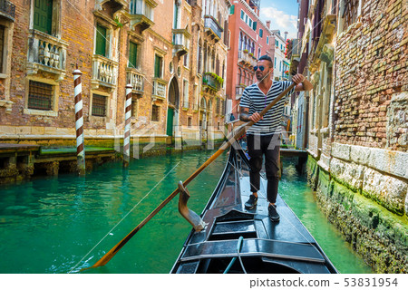 Gondolier on canal of venice 53831954