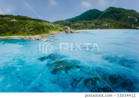 Tropical coastline of La Digue island with granite boulders and paradise beaches, view from the sea Tropical coastline of La Digue island with granite boulders and paradise beaches, view from the sea 53834412