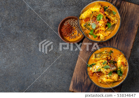 INDIAN FOOD. Traditional KERALA FISH CURRY with naan bread, gray plate, black background INDIAN FOOD. Traditional KERALA FISH CURRY with naan bread, gray plate, black background 53834647