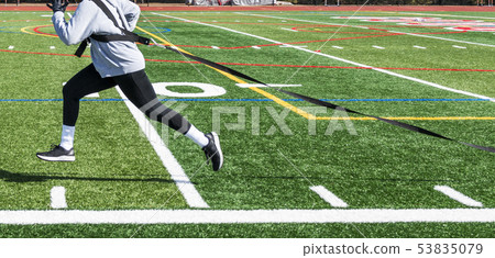 Side view of athlete pulling sled with weight 53835079