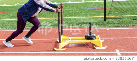 High school girl pushing sled with 75 pounds. High school girl pushing sled with 75 pounds. 53835167