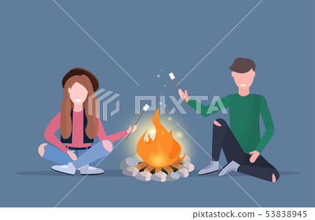 couple hikers roasting marshmallow candies on campfire hiking camping concept man woman travelers on 53838945