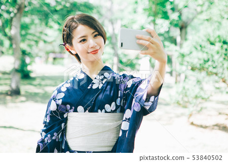 Woman in yukata taking a selfie with a smartphone 53840502