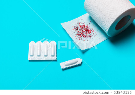 toilet paper and suppository on a blue background 53843155