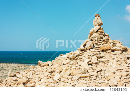hill of large stones on the beach, a mound. 53843193