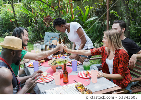 Group of happy friends standing eating and 53843605