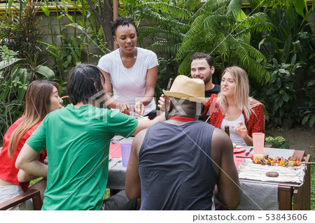 Group of happy friends standing eating and 53843606