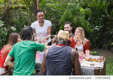 Group of happy friends standing eating and Group of happy friends standing eating and 53843608