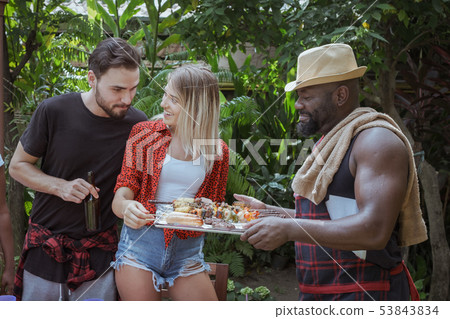 Smiling chef give barbecue to friend for dinner 53843834