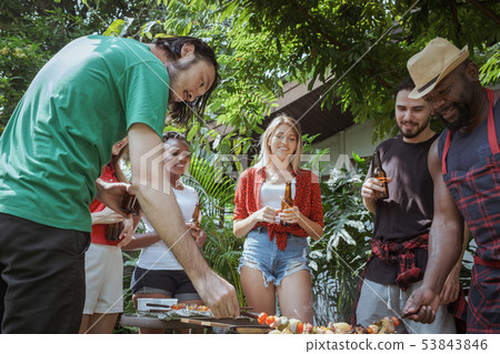 Group of happy friends standing eating and 53843846