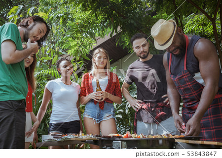 Group of happy friends standing eating and 53843847
