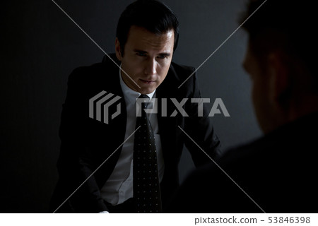 Detective interview suspect  in interrogation room 53846398