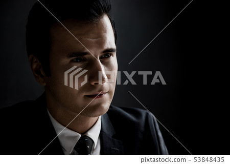 Man in shadow with serious face  53848435