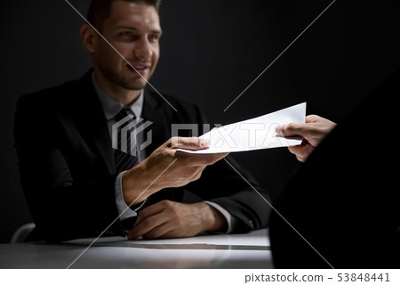 Businessman giving bribe money in the envelope 53848441