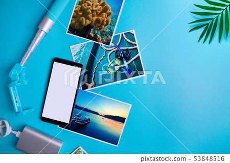 Smartphone with blank screen, flyers, photos on blue background. Mock up, flat lay. Summer concept Smartphone with blank screen, flyers, photos on blue background. Mock up, flat lay. Summer concept 53848516