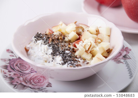 Homemade muesli with nuts and apples in a pink 53848683