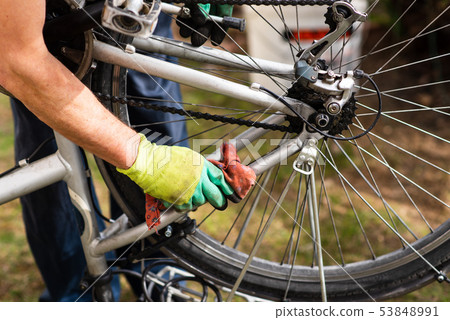 Man cleaning his bicycle for the new season Man cleaning his bicycle for the new season 53848991