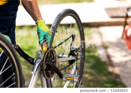 Man lubricating bicycle chain maintaining for the Man lubricating bicycle chain maintaining for the 53848993