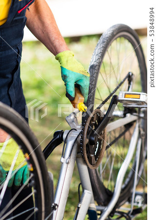 Man lubricating bicycle chain maintaining for the Man lubricating bicycle chain maintaining for the 53848994
