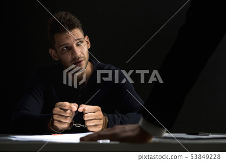 Criminal man with handcuffs in interrogation room 53849228