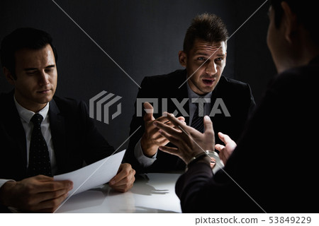 Criminal being interviewed in interrogation room  53849229