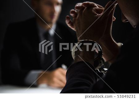 Criminal man with handcuffs in interrogation room Criminal man with handcuffs in interrogation room 53849231