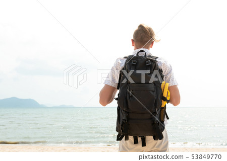 Independent backpacker standing at the beach Independent backpacker standing at the beach 53849770