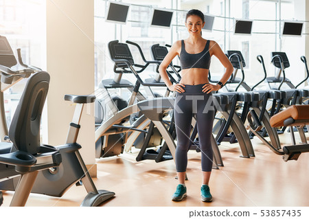Ready for workout! Full legth of deautiful and sporty woman in sportswear is keeping hands on her 53857435