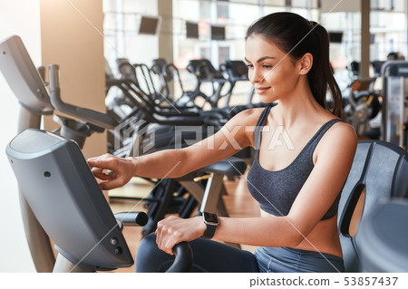 Choosing the right speed. Side view of young beautiful woman with perfect body in sportswear and 53857437