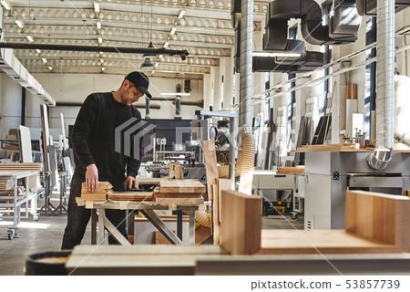 100 Quality. Craftsman in black uniform work at his workstation 53857739